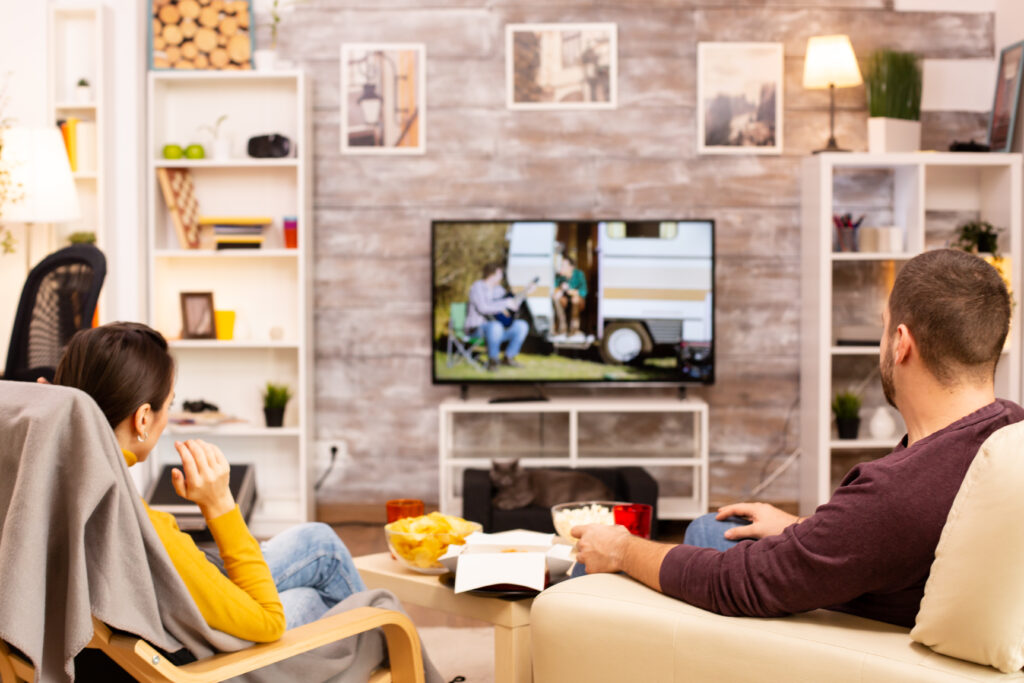 How YouTube TV Is Transforming the Streaming Experience in 2025 2 back view couple living room watching movie tv while eating takeaway food